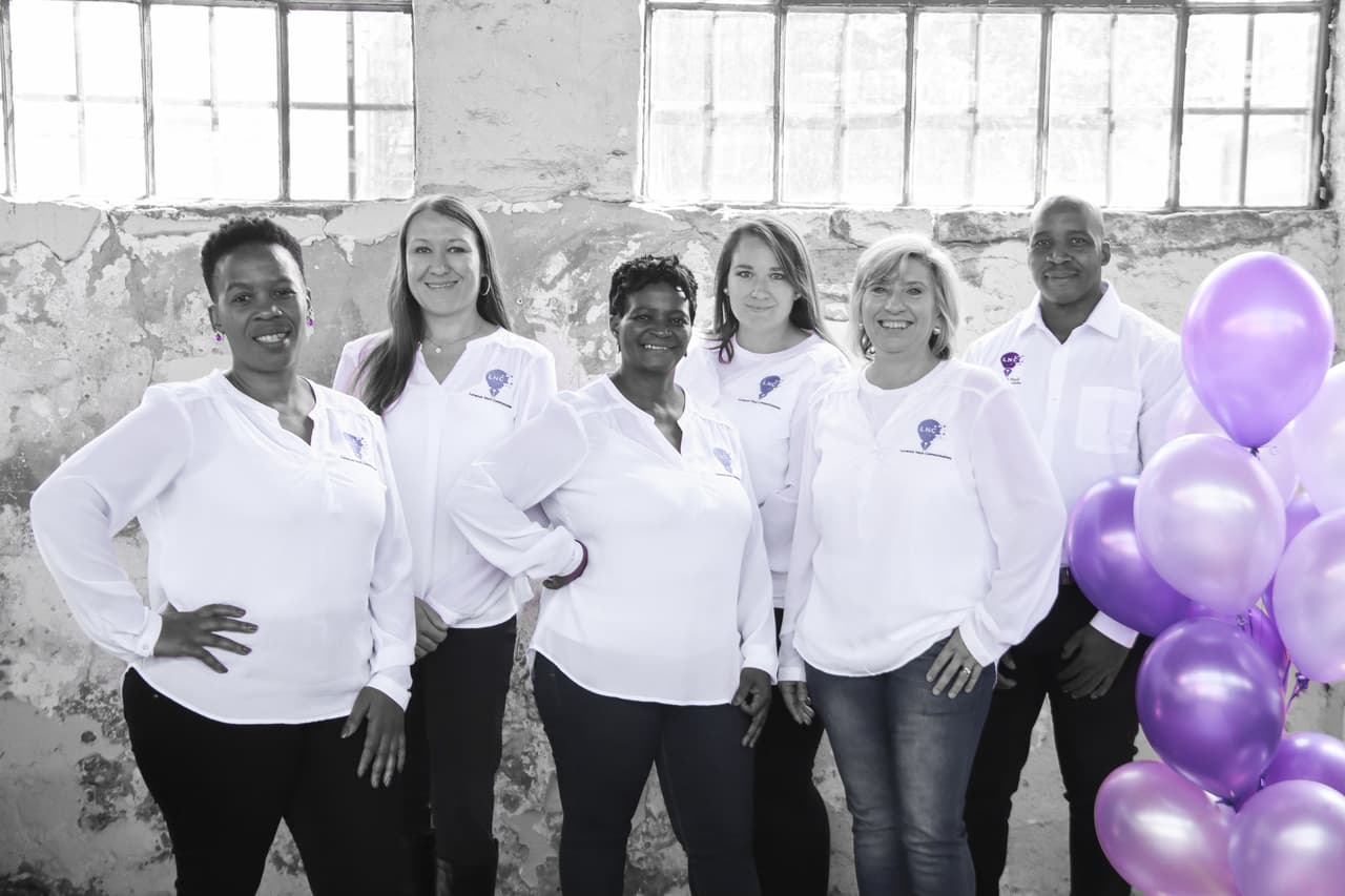 Team photo with purple balloons